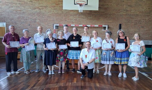 Graduation der Plus-Class, Teilnehmer mit Urkunde und Caller Ralf Denda (knieend)